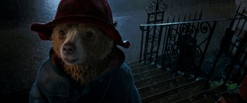 Movie still from “Paddington” (2014), directed by Paul King – A person wearing a hat and a bear costume; Close Up shot, Low angle