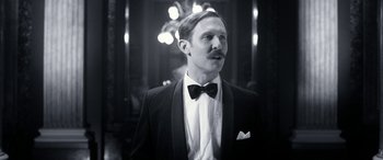 Movie still from “Paddington” (2014), directed by Paul King – A man in a suit and bow tie; Close Up shot, Low angle