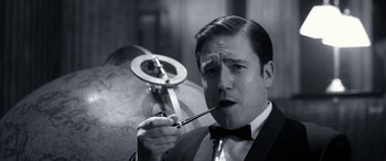 Movie still from “Paddington” (2014), directed by Paul King – A black and white photo of a man smoking a pipe; Close Up shot, Low angle