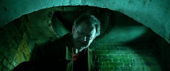 Movie still from “Paddington” (2014), directed by Paul King – A man standing under a brick wall in a room; Close Up shot, Low angle