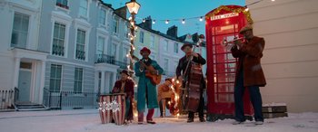 Movie still from “Paddington” (2014), directed by Paul King – A group of men playing instruments in the snow; Extreme Wide shot, Low angle