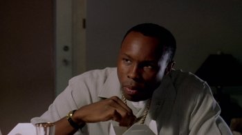 Movie still from “Paid in Full” (2002), directed by Charles Stone III – A man with a gold chain around his neck; Close Up shot, High angle