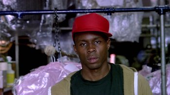 Movie still from “Paid in Full” (2002), directed by Charles Stone III – A man wearing a red hat and a green shirt; Close Up shot, Low angle