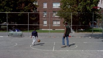 Movie still from “Paid in Full” (2002), directed by Charles Stone III – Two young men are playing basketball on a court; Extreme Wide shot, High angle