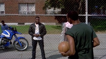 Movie still from “Paid in Full” (2002), directed by Charles Stone III – Two young men are playing basketball on a court; Wide shot, Over the shoulder angle