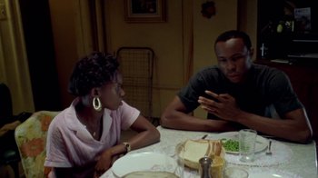 Movie still from “Paid in Full” (2002), directed by Charles Stone III – A man and a woman sitting at a dinner table; Medium shot, Over the shoulder angle