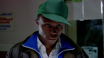 Movie still from “Paid in Full” (2002), directed by Charles Stone III – A man wearing a green hat and a jacket; Close Up shot, Low angle