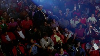 Movie still from “Paid in Full” (2002), directed by Charles Stone III – A group of people sitting in a room; Wide shot, High angle