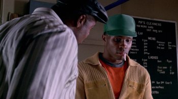 Movie still from “Paid in Full” (2002), directed by Charles Stone III – Two men standing next to each other in a room; Close Up shot, Over the shoulder angle