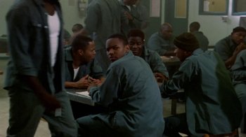 Movie still from “Paid in Full” (2002), directed by Charles Stone III – A group of men sitting at a table in a room; Medium shot, High angle