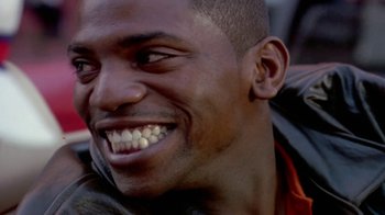 Movie still from “Paid in Full” (2002), directed by Charles Stone III – A person smiling with his mouth open; Close Up shot, Over the shoulder angle