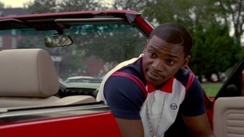 Movie still from “Paid in Full” (2002), directed by Charles Stone III – A man leaning on the hood of a red car; Close Up shot, Over the shoulder angle