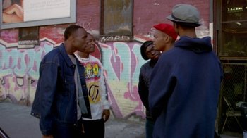 Movie still from “Paid in Full” (2002), directed by Charles Stone III – A group of young men standing next to each other on a sidewalk; Medium shot, Over the shoulder angle
