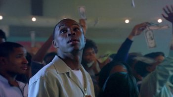 Movie still from “Paid in Full” (2002), directed by Charles Stone III – A man in a crowd of people holding up money; Close Up shot, Low angle