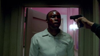 Movie still from “Paid in Full” (2002), directed by Charles Stone III – A man with blood all over his face is holding a gun in front of him; Medium shot, High angle