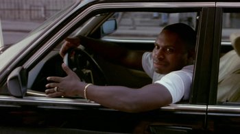 Movie still from “Paid in Full” (2002), directed by Charles Stone III – A man sitting in the driver's seat of a car; Close Up shot, Low angle