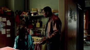Movie still from “Paid in Full” (2002), directed by Charles Stone III – A man and a woman standing in a kitchen; Medium shot, Over the shoulder angle