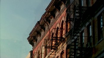 Movie still from “Paid in Full” (2002), directed by Charles Stone III – A building with a fire escape on the side of the building; Extreme Wide shot, Low angle