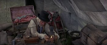 Movie still from “Paint Your Wagon” (1969), directed by Joshua Logan – An old man wearing a hat and holding a lantern; Medium shot, High angle