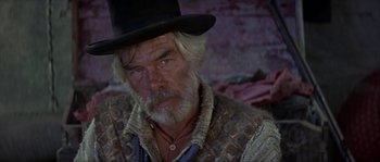 Movie still from “Paint Your Wagon” (1969), directed by Joshua Logan – An older man wearing a top hat in a western setting; Close Up shot, Low angle