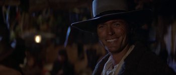 Movie still from “Paint Your Wagon” (1969), directed by Joshua Logan – A man wearing a cowboy hat smiling for the camera; Close Up shot, Low angle