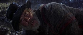 Movie still from “Paint Your Wagon” (1969), directed by Joshua Logan – An old man with an axe in his hand; Close Up shot, Low angle