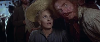 Movie still from “Paint Your Wagon” (1969), directed by Joshua Logan – A man and a woman wearing a straw hat; Close Up shot, Over the shoulder angle