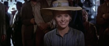 Movie still from “Paint Your Wagon” (1969), directed by Joshua Logan – A woman wearing a straw hat smiling for the camera; Close Up shot, Low angle