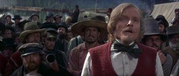 Movie still from “Paint Your Wagon” (1969), directed by Joshua Logan – A group of men standing next to each other in a crowd; Close Up shot, Low angle