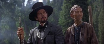 Movie still from “Paint Your Wagon” (1969), directed by Joshua Logan – A man with a beard wearing a top hat and a suit; Close Up shot, Low angle