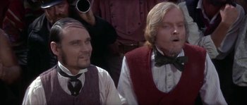 Movie still from “Paint Your Wagon” (1969), directed by Joshua Logan – Two men in vests and bow ties are looking at something; Close Up shot, Low angle
