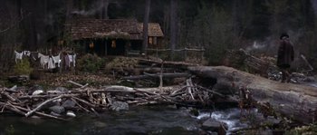 Movie still from “Paint Your Wagon” (1969), directed by Joshua Logan – A cabin in the middle of the woods near a river; Extreme Wide shot, High angle