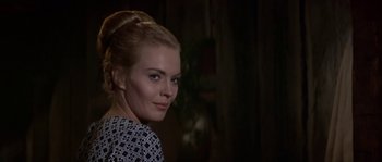 Movie still from “Paint Your Wagon” (1969), directed by Joshua Logan – A beautiful woman with blonde hair standing in front of a wall; Close Up shot, Over the shoulder angle