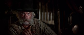 Movie still from “Paint Your Wagon” (1969), directed by Joshua Logan – An old man with a beard and a hat is holding a pipe in his mouth; Close Up shot, Low angle