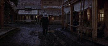 Movie still from “Paint Your Wagon” (1969), directed by Joshua Logan – A man in a cowboy hat walking down a street; Wide shot, Low angle