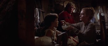 Movie still from “Paint Your Wagon” (1969), directed by Joshua Logan – A man and a woman sitting on a bed eating food; Medium shot, Over the shoulder angle