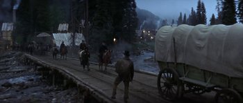 Movie still from “Paint Your Wagon” (1969), directed by Joshua Logan – A group of men riding horses down a dirt road; Wide shot, High angle