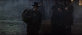 Movie still from “Paint Your Wagon” (1969), directed by Joshua Logan – A group of men standing next to each other on a street; Medium shot, Low angle