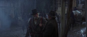 Movie still from “Paint Your Wagon” (1969), directed by Joshua Logan – Two men in hats and jackets talking to each other; Medium shot, Over the shoulder angle
