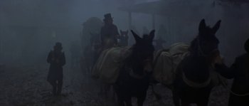 Movie still from “Paint Your Wagon” (1969), directed by Joshua Logan – A group of people riding on the back of a donkey; Wide shot, Low angle