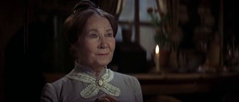 Movie still from “Paint Your Wagon” (1969), directed by Joshua Logan – An older woman wearing a dress with a bow around her neck; Close Up shot, High angle