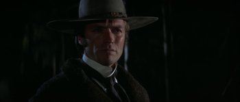 Movie still from “Paint Your Wagon” (1969), directed by Joshua Logan – A man wearing a hat and a suit; Close Up shot, Low angle