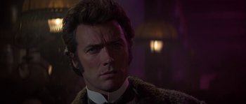 Movie still from “Paint Your Wagon” (1969), directed by Joshua Logan – A person wearing a suit and tie; Close Up shot, Over the shoulder angle