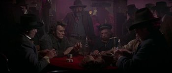 Movie still from “Paint Your Wagon” (1969), directed by Joshua Logan – A group of people sitting around a table; Medium shot, Over the shoulder angle