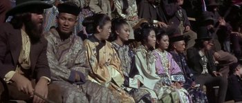 Movie still from “Paint Your Wagon” (1969), directed by Joshua Logan – A group of women sitting in a row wearing asian clothing; Medium shot, High angle