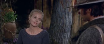 Movie still from “Paint Your Wagon” (1969), directed by Joshua Logan – A woman standing next to a tree in a forest; Medium shot, Over the shoulder angle