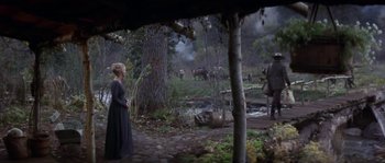 Movie still from “Paint Your Wagon” (1969), directed by Joshua Logan – A woman standing in front of a tree in a forest; Wide shot, High angle