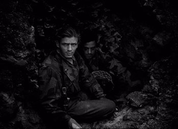 Movie still from “Paisan” (1946), directed by Roberto Rossellini – Two young men sitting on the ground in the dark; Medium shot, High angle