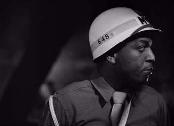 Movie still from “Paisan” (1946), directed by Roberto Rossellini – Black and white photograph of a man wearing a helmet; Close Up shot, Low angle