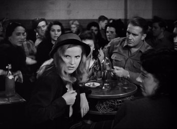 Movie still from “Paisan” (1946), directed by Roberto Rossellini – A group of people sitting around a table; Medium shot, Over the shoulder angle